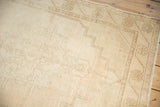 Distressed ivory Oushak rug runner pile with muted floral design and time-softened texture.