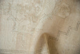 Distressed Oushak runner texture, showing abrashed ivory tones and visible foundation wear.