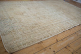 Distressed vintage Oushak rug showing worn pile, visible foundation, and soft neutral colors.