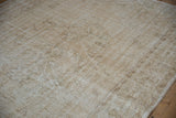Distressed vintage Oushak rug's worn ivory and beige pile, revealing foundation.