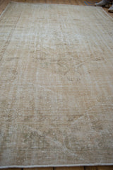 Vintage Distressed Oushak rug's worn texture in faded beige and ivory tones.