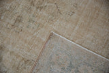 Distressed vintage Oushak rug showing worn pile, exposed foundation, and selvage.