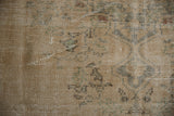 Worn pile texture of a distressed Oushak carpet, revealing foundation with muted beige and seafoam patterns.