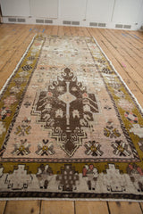 Distressed vintage Oushak runner, featuring pale olive border and dusty blush floral field.