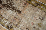 Distressed pile of vintage Oushak runner with worn brown, olive green, and blush motifs, revealing foundation.