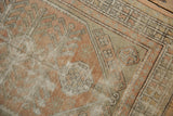 Distressed vintage Oushak rug detail showing the rhythmic geometric floral border and field in peach, ivory, seafoam.