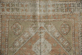 Distressed Oushak rug border detail, geometric floral pattern with arrowed contour, peach and ivory.