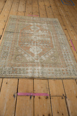Distressed vintage Oushak rug's rhythmic geometric border and fringe in peach, ivory, dusty seafoam.