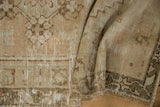 Worn pile texture and geometric border on a distressed vintage Oushak rug corner.