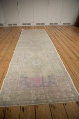 Distressed Oushak rug runner showcasing faded patterns in silver, dusty mauve, and terracotta.