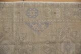 Textured detail of vintage distressed Oushak runner, showing faded dusty mauve medallion.