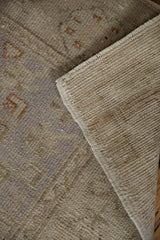 Tightly woven reverse and distressed pile of a vintage Oushak runner with faded terracotta patterns.
