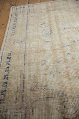 Distressed vintage Oushak rug with worn ivory pile and visible foundation texture.