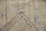 Close-up of distressed vintage Oushak rug revealing worn pile, foundation, and woven cobalt blue reverse.