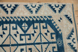 Geometric navy and ivory hook-and-latch patterns on a distressed vintage Oushak rug.