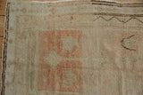 Distressed vintage Oushak pile, showing even wear, pale blush tones, and secure selvage.