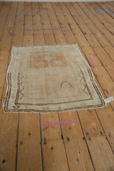Vintage distressed Oushak rug corner with even wear, pale ivory pile, and zigzag brown border.