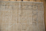 Close-up of the distressed Oushak's low pile, showing wear across the knot heads.