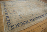 Distressed Oushak rug corner with faded cobalt blue scrolling serrated leaf border.