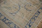 Distressed texture of vintage Oushak rug with faded cream, cobalt blue, and seafoam green patterns.