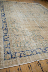 Distressed vintage Oushak rug, abrashed cream field with faded cobalt blue and seafoam tendrils.