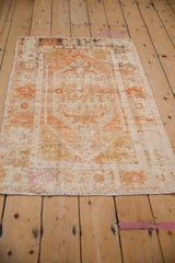 Distressed vintage Oushak rug bottom edge, showing foundation wear and faded orange tones.