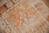 Distressed vintage Oushak rug texture, showing worn ivory, tangerine, and coffee brown.