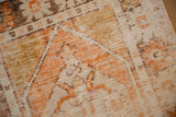 Distressed Oushak rug with ivory, orange, and brown worn pile revealing foundation.