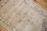 Distressed Oushak rug pile revealing foundation wear with time-softened silver and charcoal designs.