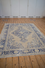 Distressed Oushak carpet with sharply serrated medallion and worn cream and blue pile.