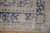 Distressed vintage Oushak carpet border, cream and navy patterns with visible foundation.
