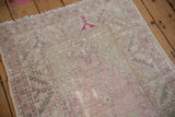 Distressed Oushak rug with faded pink, antique ivory, and beige tones, showing mostly even wear.
