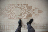 Abrashes across vintage Oushak runner, showing faded primitive floral and geometric designs.