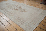 Distressed vintage Oushak rug with ivory and brown lozenge medallion and quatrefoil border.