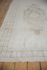 Oushak runner's pale coffee geometric border, showing even wear to knot heads and faint foundation.