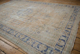 Distressed Oushak carpet with worn pile, visible foundation, and faded sky blue motifs.
