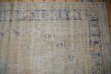 Distressed vintage Oushak rug with visible foundation, faded sky blue and pale green patterns.