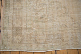 Distressed vintage Oushak rug pile showing even wear, exposed knot heads, and soft cream patterns.