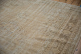 Distressed Oushak rug pile texture, showing cream, ivory, and pale coffee brown tones.