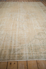 Distressed Oushak carpet texture revealing visible knot heads, cream, and pale sea foam pattern.
