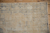 Heavily distressed cream and faded denim blue Oushak rug pile with visible foundation.
