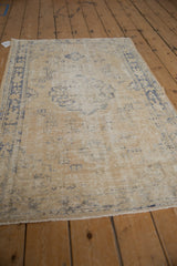 Distressed vintage Oushak rug end, showing decorative wear and visible foundation.