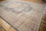 Distressed vintage Sparta carpet close-up, worn pile with faded floral patterns and exposed foundation.
