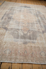 Distressed Sparta carpet section with faded floral patterns in mauve, ivory, and slate blue.