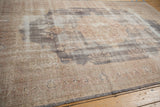 Distressed Sparta carpet with faded floral motifs and low pile, featuring time-softened neutral hues.