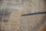 Distressed vintage rug showing worn pile, exposed foundation, and reverse side with markings.