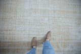 Vintage distressed Oushak rug with worn texture in soft beige, cream, and sand tones.