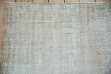 Worn beige, cream, and sand textured pile of a distressed vintage Oushak rug.