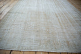 Textured vintage Oushak pile with distressed wear showing foundation, beige, cream, and cobalt blue.
