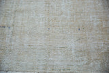 Textural detail of distressed beige Oushak carpet pile with wear to foundation.